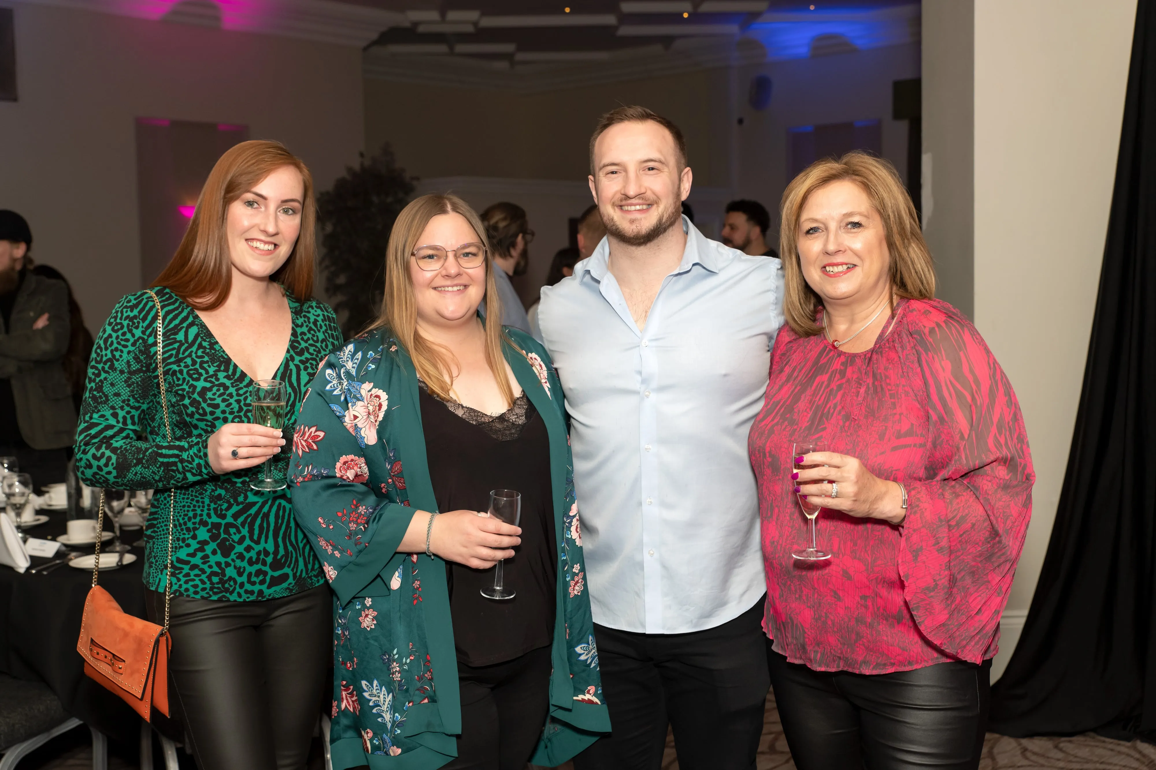 Smiling guest with champagne flute at corporate evening drinks reception