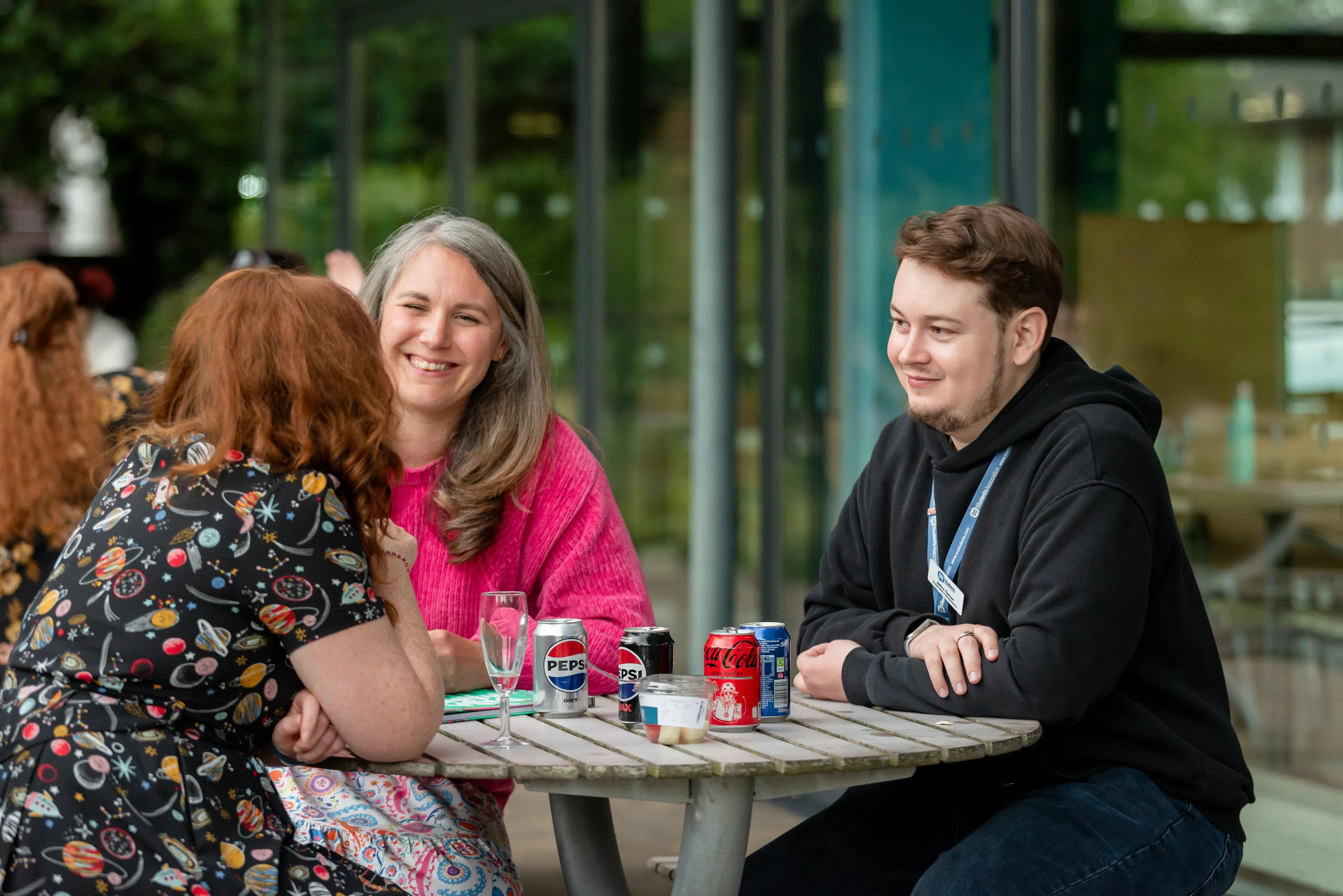 Conference attendee portrait — woman in red top with branded lanyard, candid moment in a corporate venue