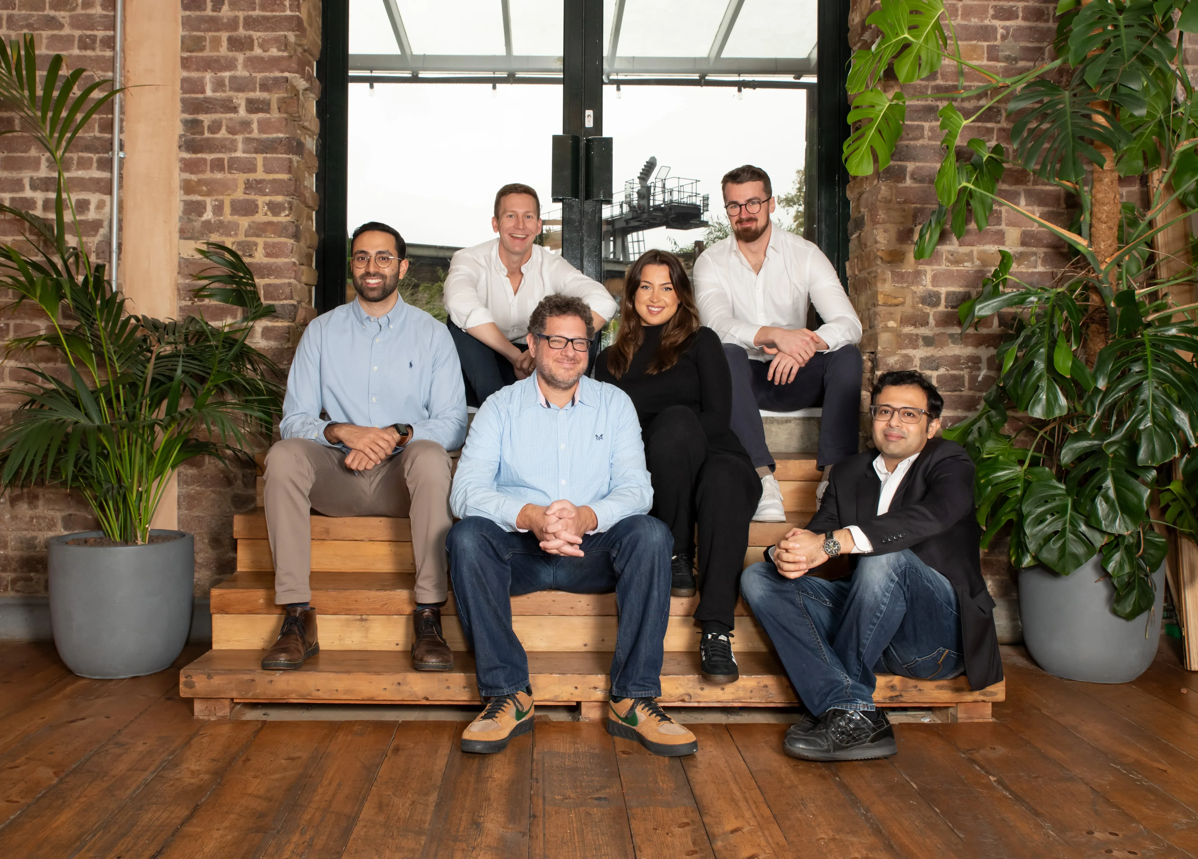 Sprout.ai team of six on wooden steps in industrial loft office