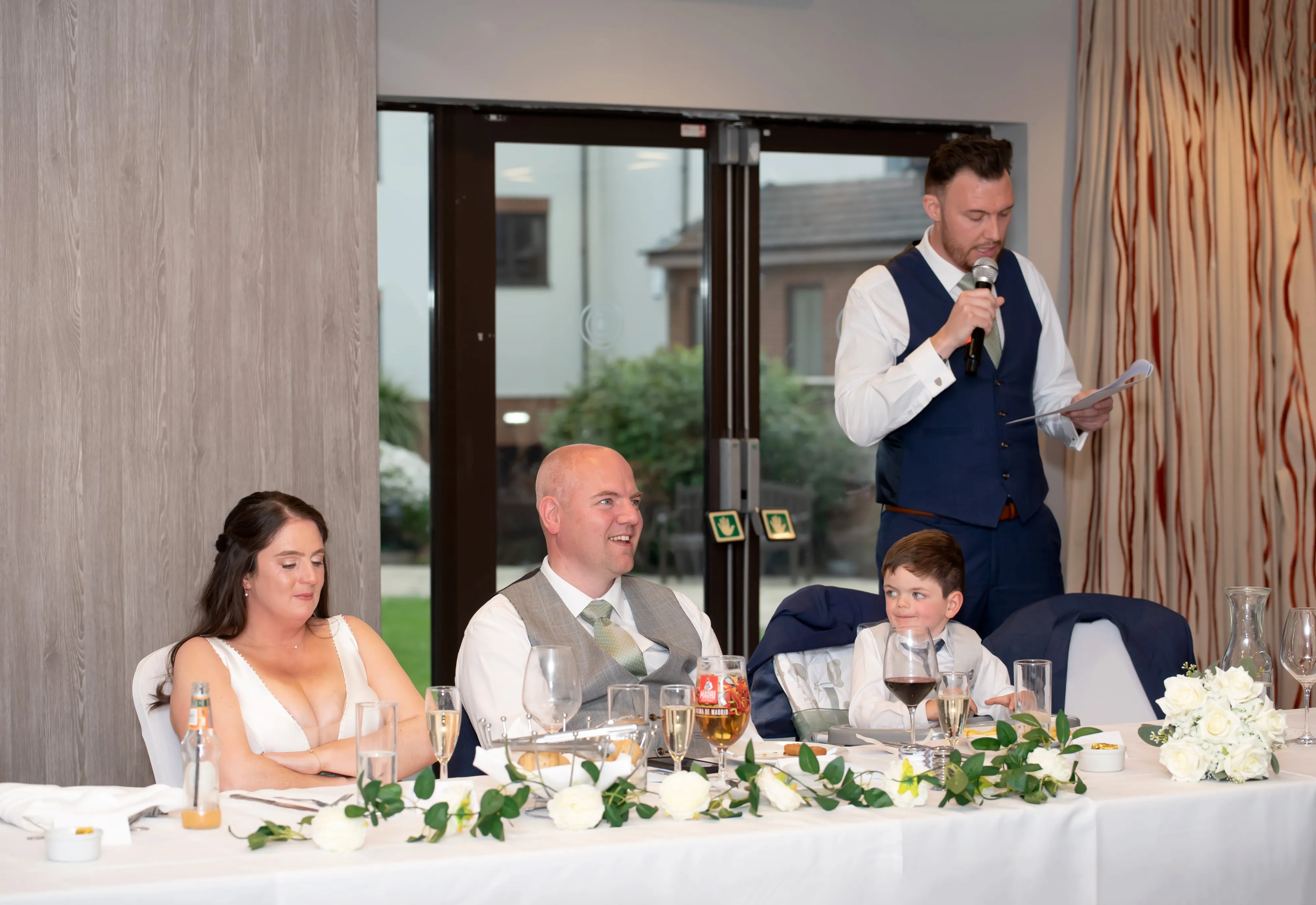 Best man delivers wedding speech as bride and groom listen at Belfry top table