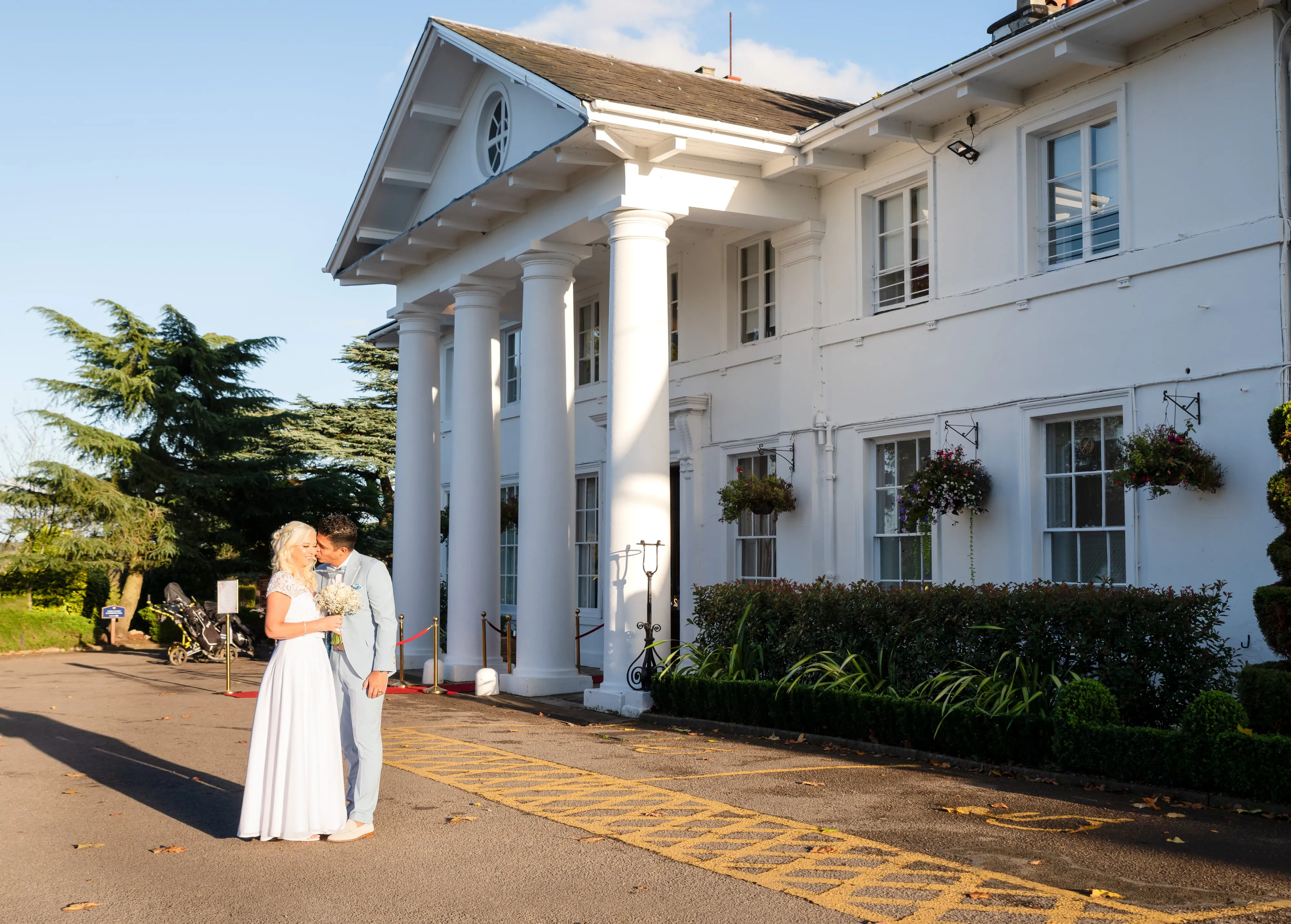 Bride and groom kiss outside Dyrham Park