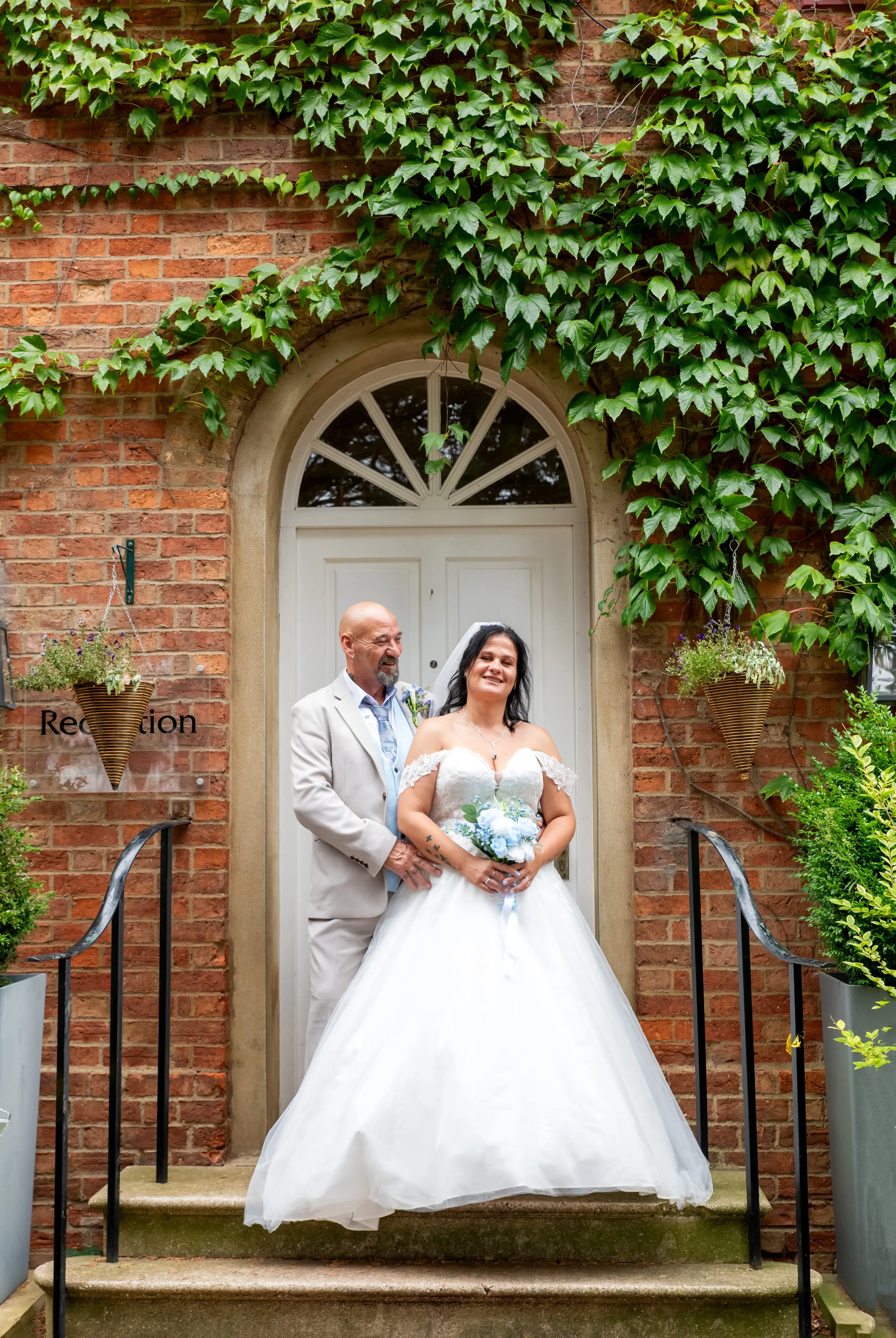 Bride and groom on doorstep of ivy-covered country house at Holiday Inn Express MK East