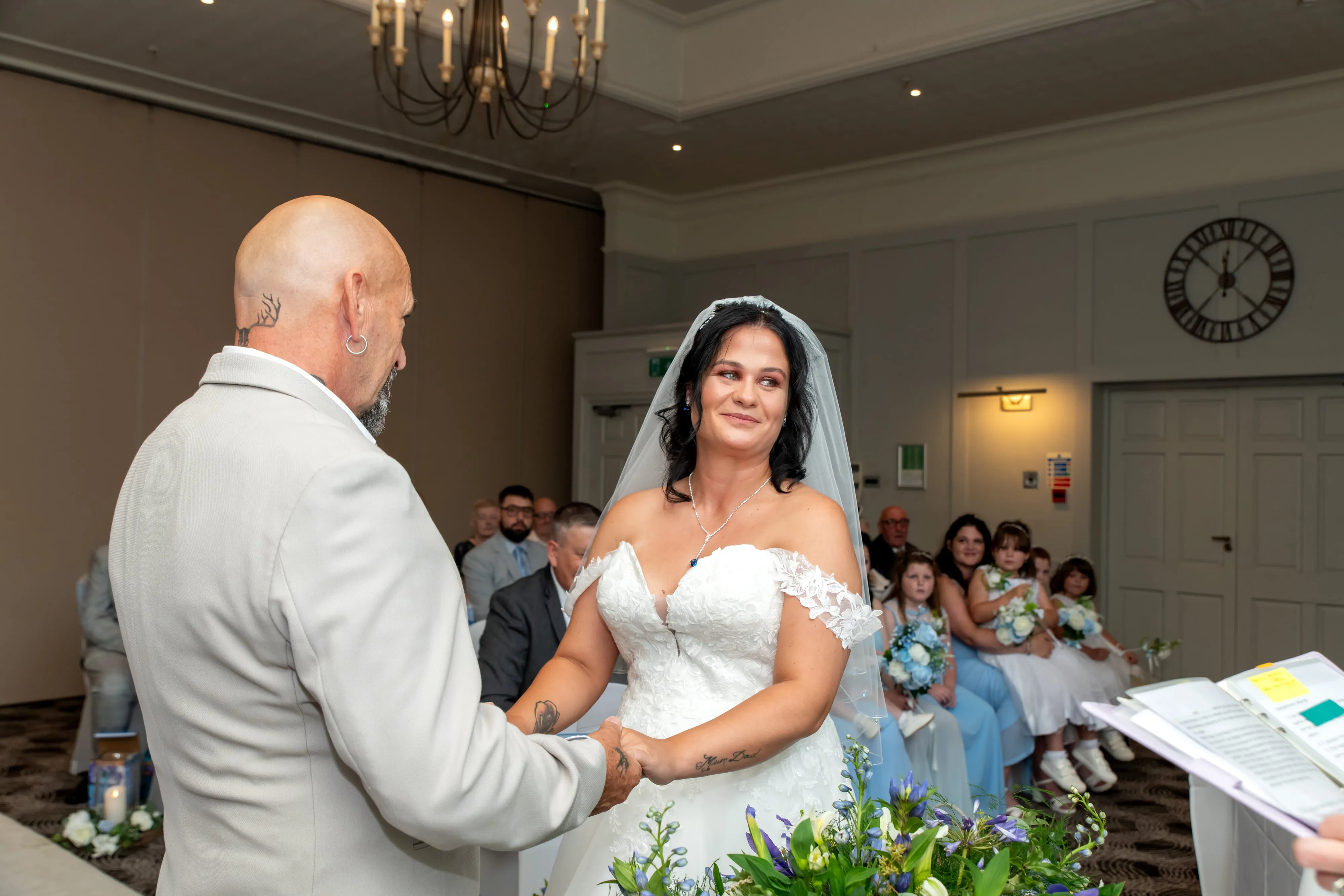 Bride and groom hold hands at the altar during their Holiday Inn Milton Keynes wedding ceremony