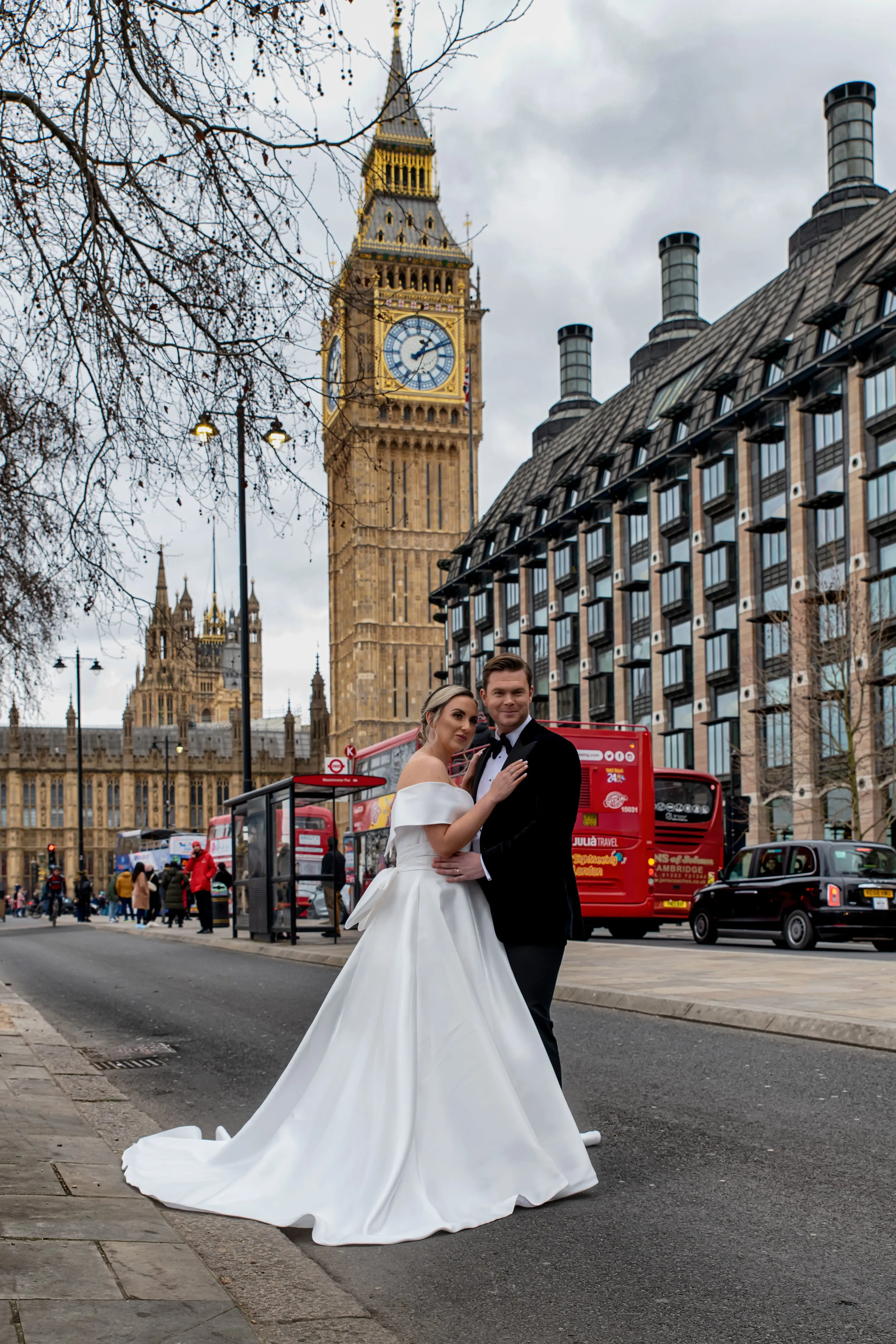 Bride in ballgown embraces groom under Big Ben clock tower in London