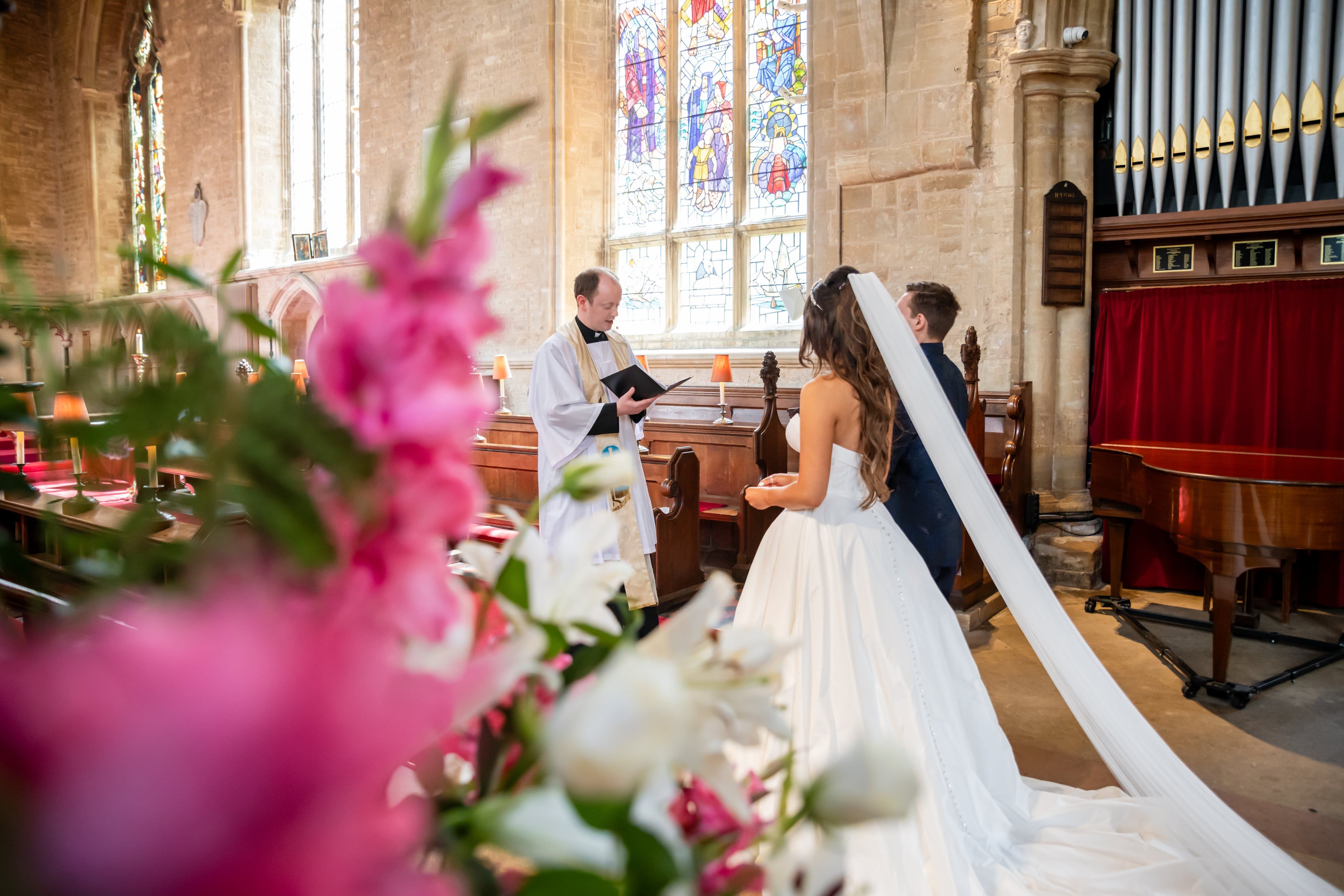 Bride walks down the aisle on her father's arm holding a purple bouquet