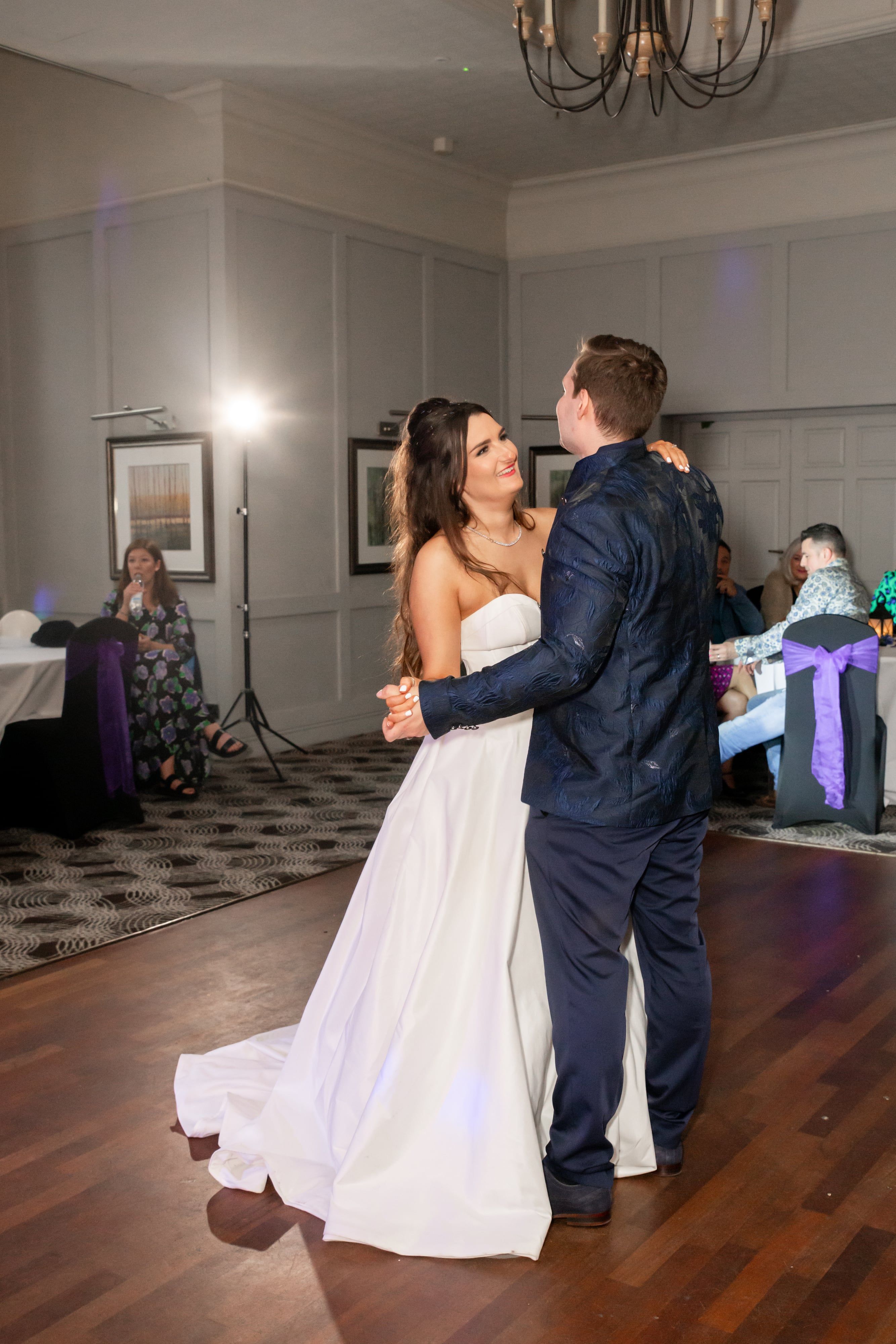 First dance in the panelled suite at Holiday Inn Milton Keynes East, guest tables dressed with purple sashes
