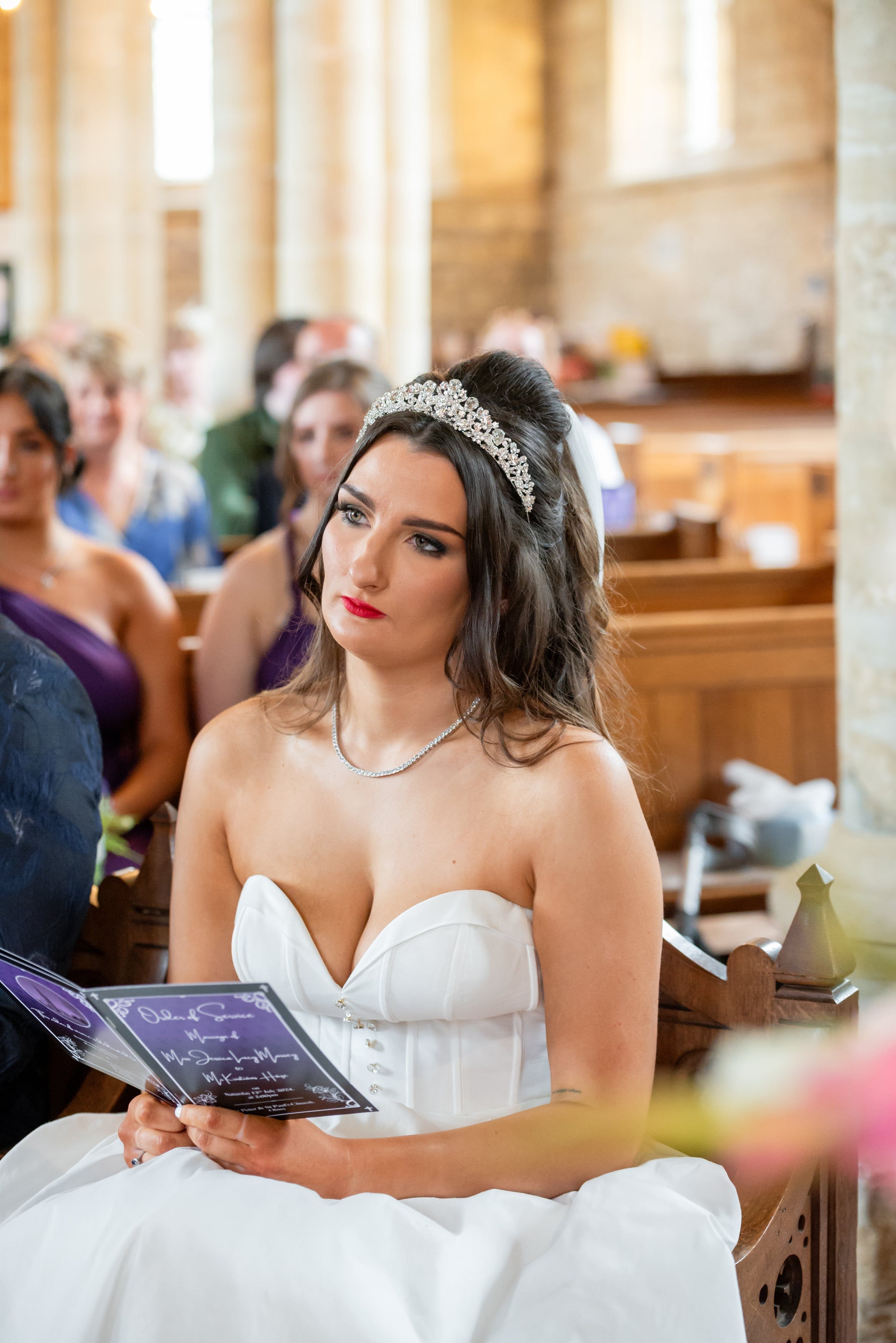 Bride follows the order of service, tiara catching the light