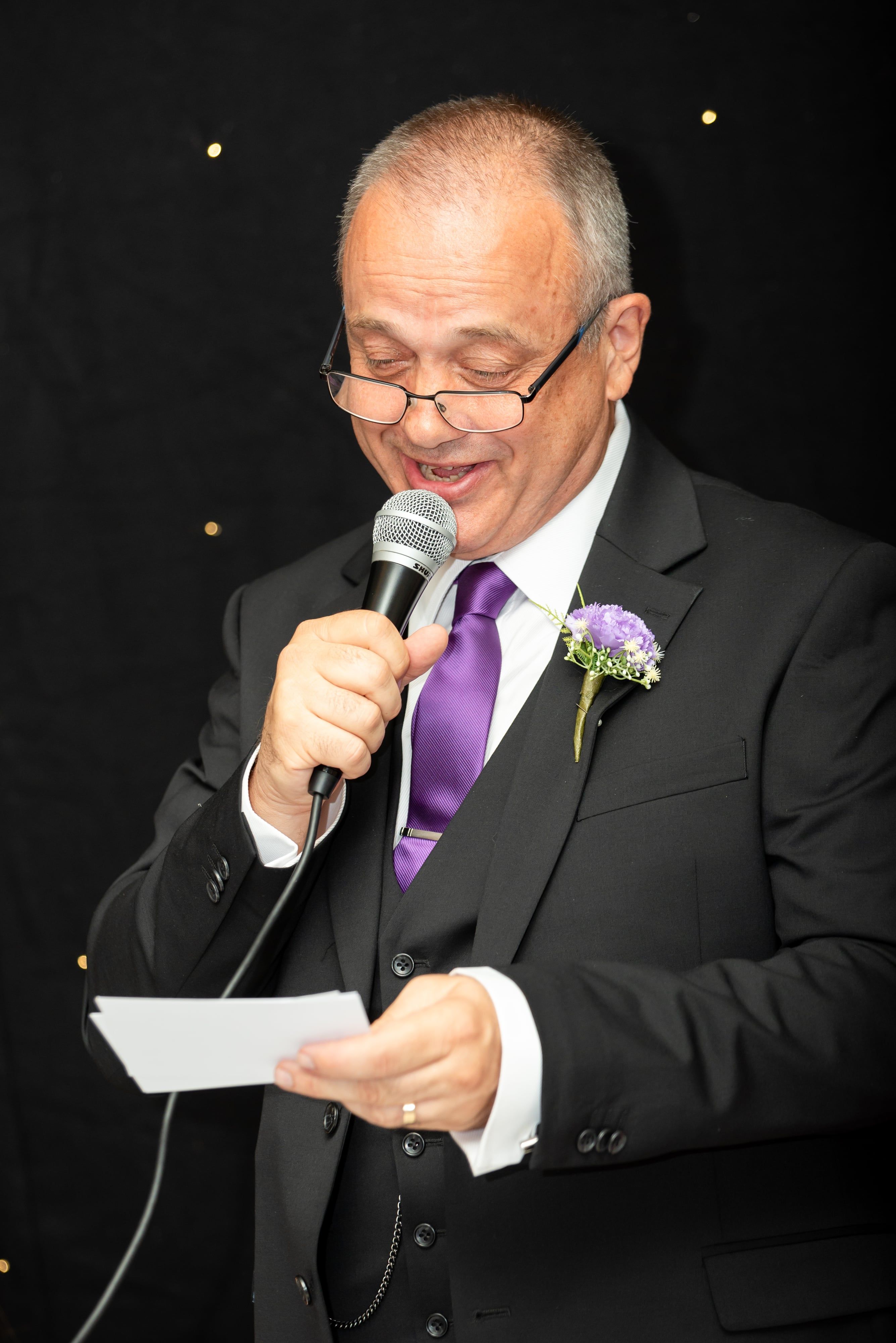 Father of the bride reads his speech into the microphone
